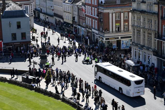 Police hold back the crowds as a coach arrives outside St George’s Chapel (Justin Tallis/PA)