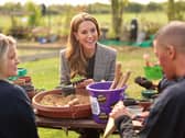 Kate smiling while seated at a table outside with other people