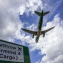 A plane flying above a Heathrow road sign