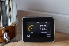 An energy monitor displaying electricity usage and cost per hour