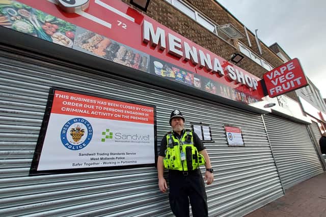 A police officer pictured outside Menna Shop in Cradley Heath High Street