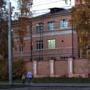 A woman with a child walks past the building of the Irkutsk Anti-Plague Research Institute of Siberia and the Far East in Irkutsk, Russia