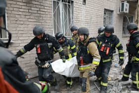 Rescue workers carry a body from the rubble of a residential building