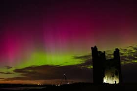 The aurora borealis lighting up skies over the ruins of Dunstanburgh Castle