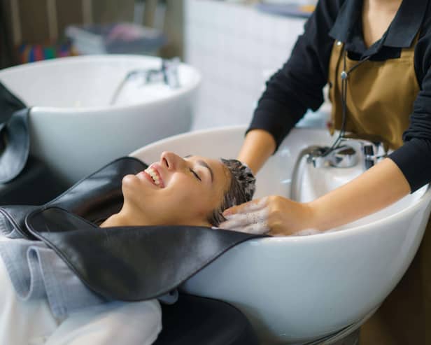 A hairdresser applying shampoo and massaging the hair of a customer