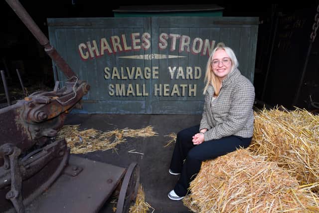Emma next to the gates used in the series
