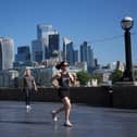 A woman runs with a city skyline in the background