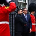 Volodymyr Zelensky and Andy Burnham shake hands outside 10 Downing Street, flanked by soldiers in red dress uniform