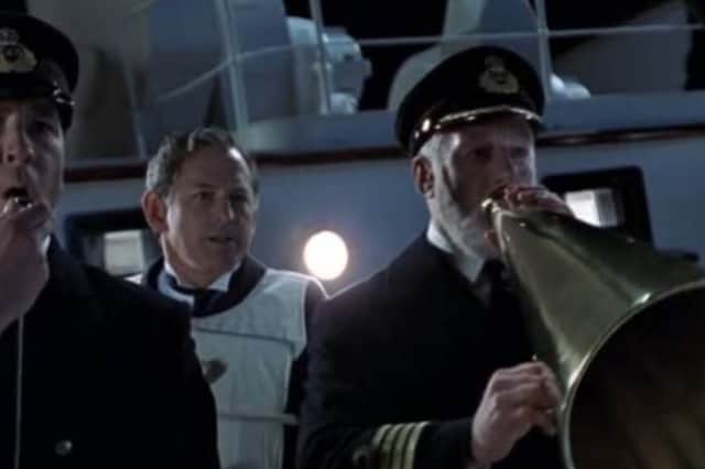 Captain Edward Smith, played by Bernard Hill,  using a megaphone to command the lifeboats to return in the 1997 film Titanic