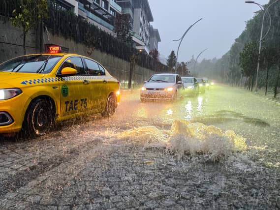 Vehicles drive along a partially flooded road during heavy rain in Istanbul
