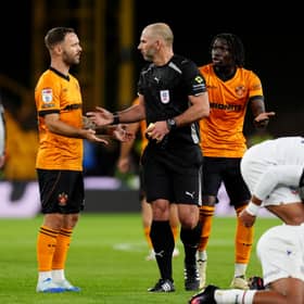 Referee Tim Robinson speaks with Adam Armstrong after showing a yellow card to Mateus Mane