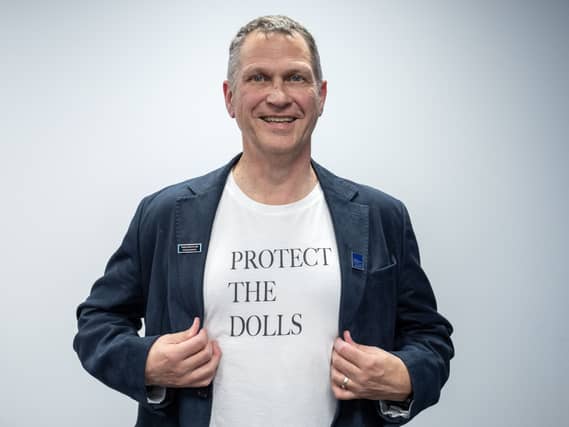 Mike Corbett wearing a Protect The Dolls T-shirt