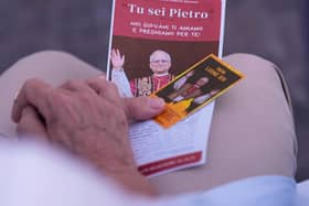 A woman holds a picture of the Pope