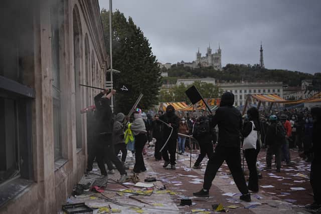 Protesters attack a tourism office during a demonstration against rising living costs, joining students’ grievances, in Lyon, France (Laurent Cipriani/AP)