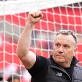 Oldham manager Micky Mellon punches his fist in the air