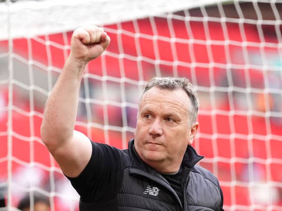Oldham manager Micky Mellon raises a fist in celebration