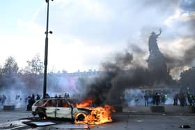 A car burns at Place de La Republique during a protest against rising living costs in Paris