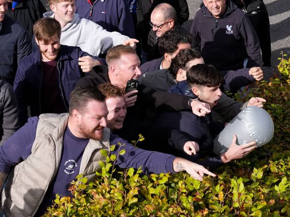 Crystal Palace fans gesture towards Brighton fans