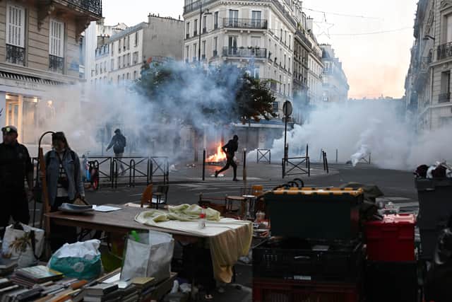 A protester runs through tear gas during clashes with police in the French capital (Emma Da Silva/AP)
