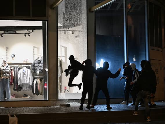 Youths break a store window
