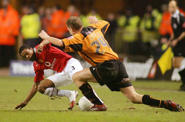 Gabor Gyepes tackles Manchester United left back Patrice Evra