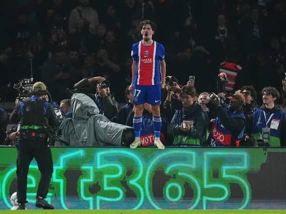 Vitinha stands on an advertising hoarding to celebrate after scoring in Paris St Germain's win over Barcelona