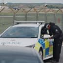 Police patrol the perimeter as a US Air Force Rockwell B-1 Lancer bomber lands at RAF Fairford