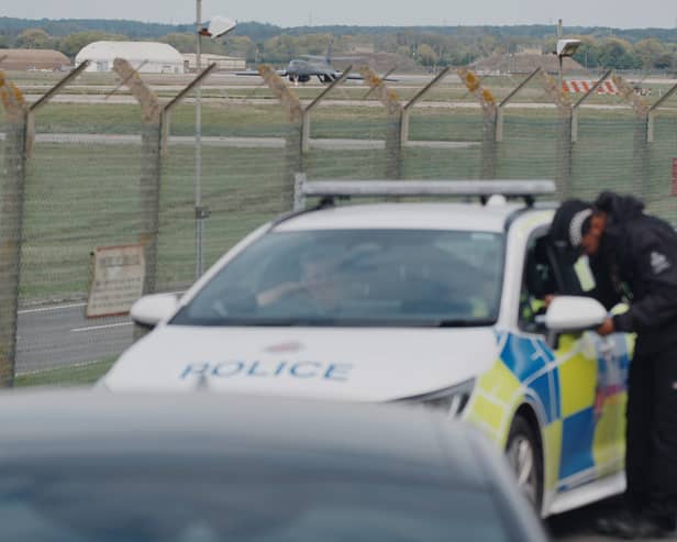 Police patrol the perimeter as a US Air Force Rockwell B-1 Lancer bomber lands at RAF Fairford