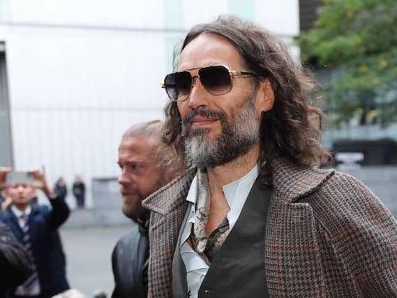 Russell Brand arrives at court in sunglasses
