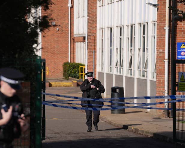 Police officers and police tape outside a school