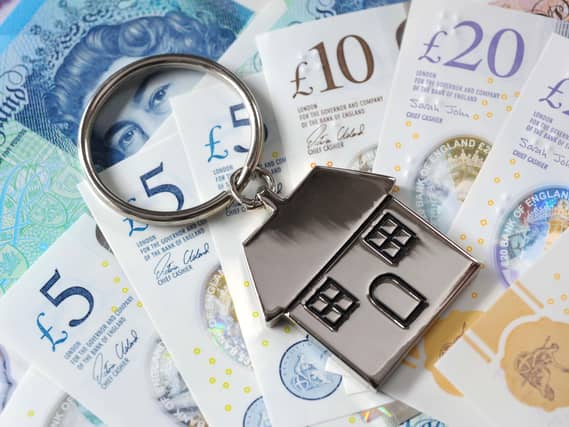 A house keyring on a pile of cash notes