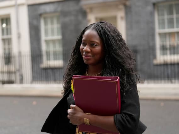 Miatta Fahnbulleh smiling while walking on Downing Street, carrying a red ministerial folder
