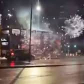A bus in Birmingham, under attack from somebody shooting fireworks at it.