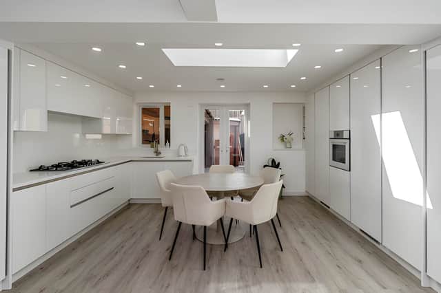 A bespoke kitchen with sleek cabinetry, quartz work surfaces and integrated appliances forms the centrepiece of the open-plan kitchen and dining area.