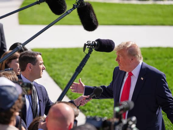 Donald Trump, right, fielding questions from reporters