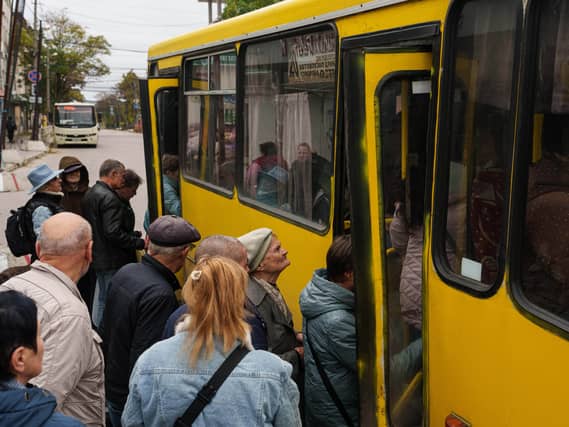 People board a bus during a local ceasefire linked to efforts to evacuate residents of Oleshky in Ukraine