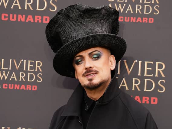 Headshot of Boy George, wearing a black black hat while posing for photos at an even