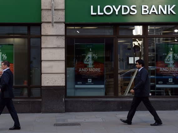 Two men wearing suits walking past a Lloyds branch