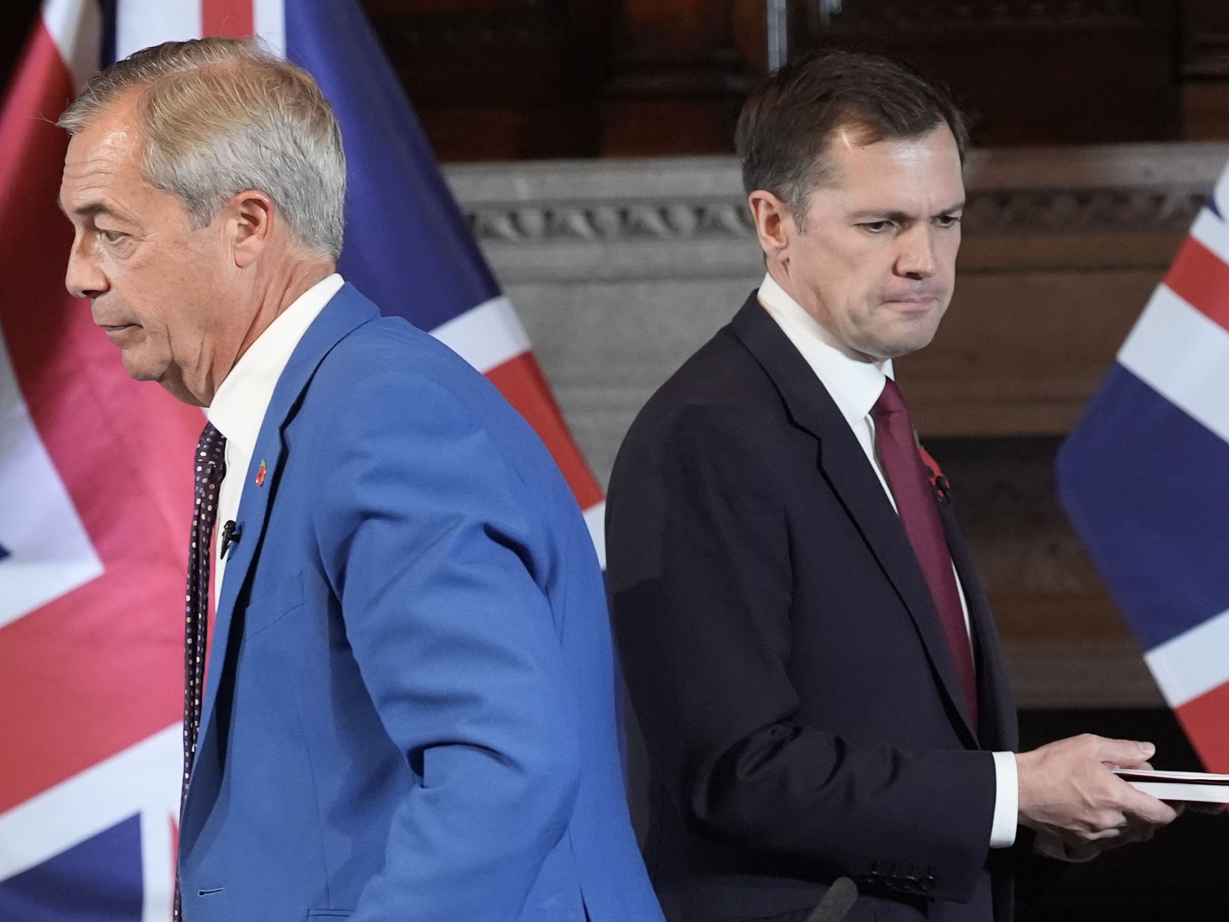 Nigel Farage and Robert Jenrick standing back to back