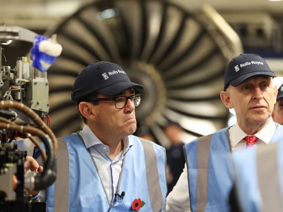 Andy Burnham and John Healey wearing hi-vis jackets in front of a jet engine