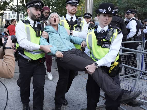 Police officers remove a demonstrator during a protest organised by Defend Our Juries outside the US embassy in south London in support of Palestine Action
