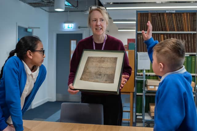 Catherine Dicken, Local Studies and Outreach Librarian, Walsall Archives, uncovers artefacts from the town's archives with young learners from New Invention Learning Academy.