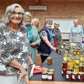 Members eagerly purchasing preserves, with Chairman Chris Ballett, left of Melanie Latham