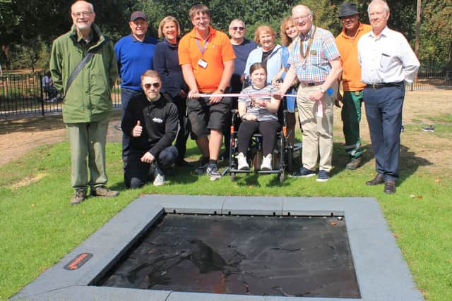 Grace Riley cuts the ribbon to open the new bouncer in Beacon Park assisted by President of The Rotary Club of Lichfield St Chad Michael Mullarkey (right) and Park Ranger James Myers