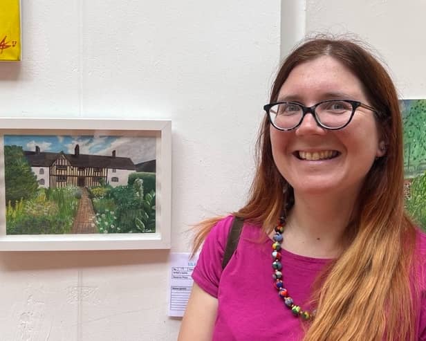 Little Art Lab founder Julianne Cash alongside her artwork at an exhibition.