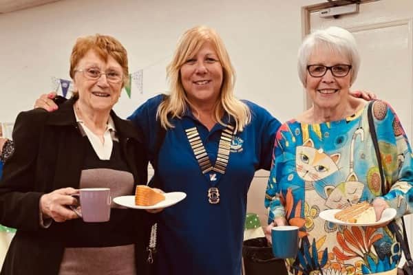 Ladies from St Augustine's Church collecting their cake and coffee with President Debra.