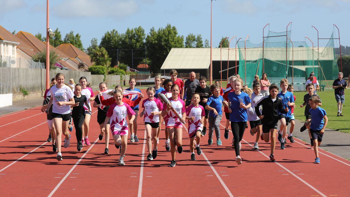 Children relaying the baton around the track at FB Fields in Jersey