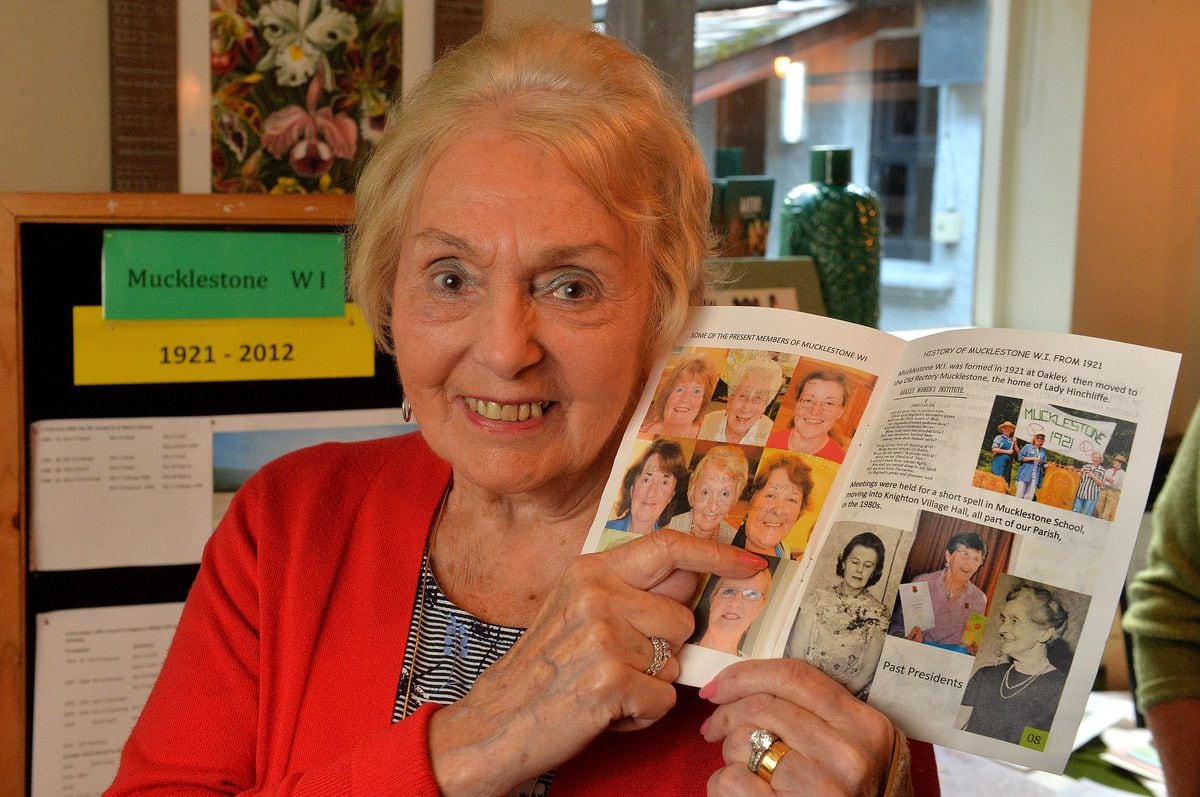 Sandra Pearce, with a photo of herself in a book celebrating Mucklestone WI 