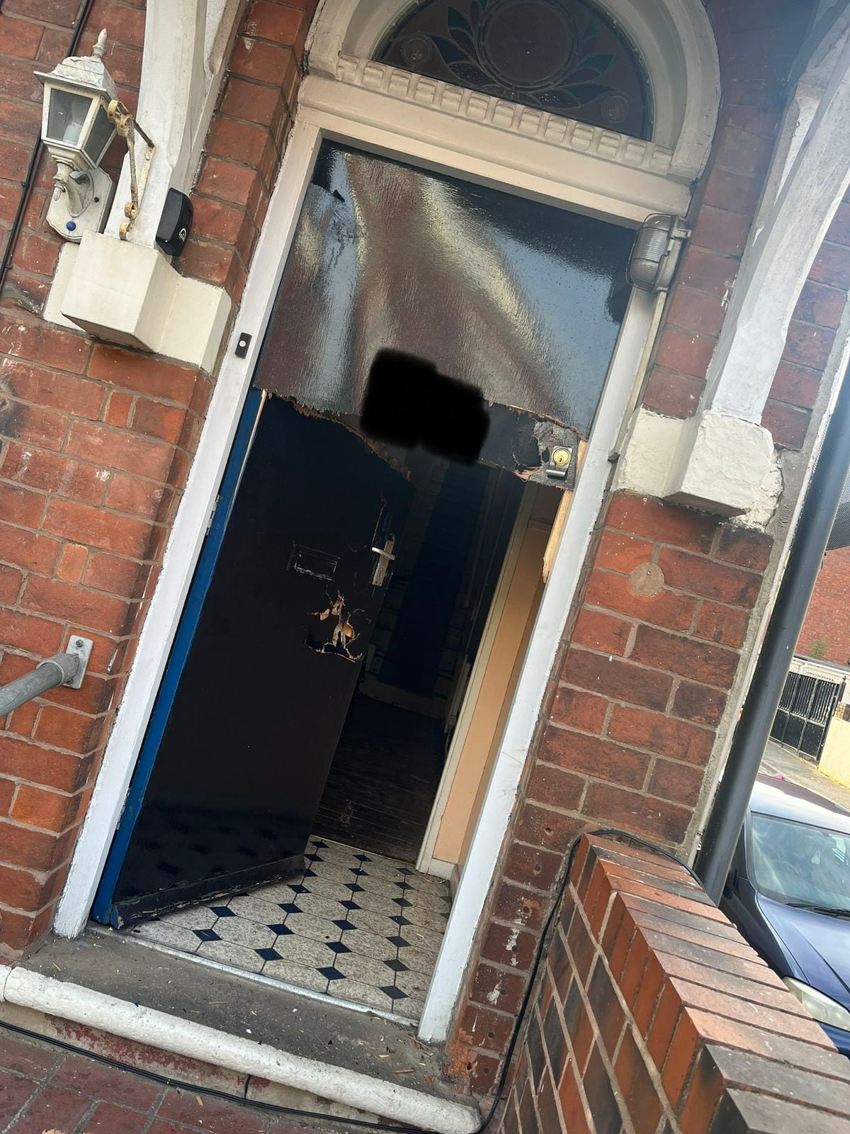 The damaged front door after police forced their way in. Photo: @DudleyTownWMP