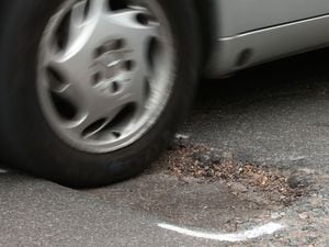 A car hits a pothole on a road in Islington, London